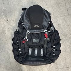 a black backpack sitting on top of a cement floor