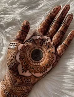 the hand is decorated with henna and intricate designs