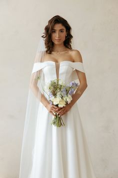 a woman in a wedding dress holding a bouquet