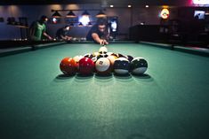 billiards are lined up on the table in a dark room with other pool balls