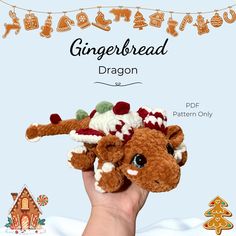 a hand holding a small stuffed animal in it's right hand with gingerbread dragon on top