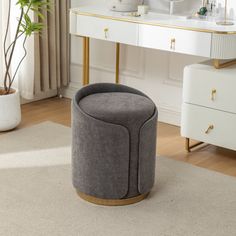 a bathroom with a vanity, mirror and stool in the corner next to a rug