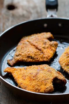 some fried fish in a frying pan on a table