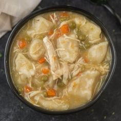 a bowl filled with chicken noodle soup on top of a table