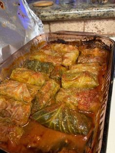 a casserole dish with meat and vegetables in it sitting on a stove top