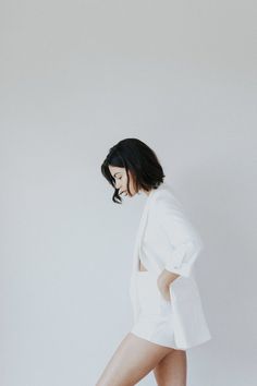 a woman in short shorts and white blazer