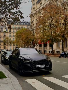 a black car is parked on the side of the road