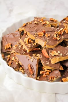 a white bowl filled with chocolate and nuts