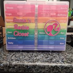 two plastic storage boxes with labels on them sitting on a countertop in front of a window