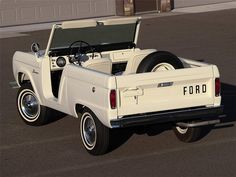 an old ford pickup truck parked in a parking lot with the hood open and it's flatbed