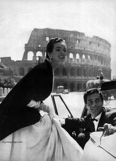 a woman sitting in the driver's seat of a car next to a man