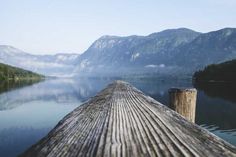 a wooden dock with mountains in the background