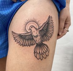 a tattoo on the thigh of a woman's leg with a bird flying above it