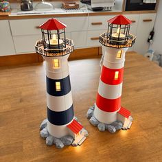 two lighthouses sitting on top of a wooden table next to each other in a kitchen