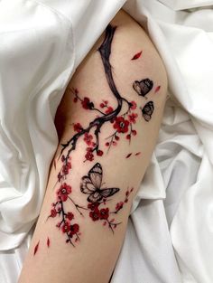 a woman's arm with red flowers and butterflies on it