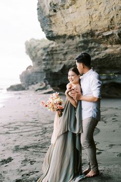 a man and woman embracing on the beach