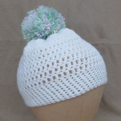 a white knitted hat with a green pom - pom on it's top