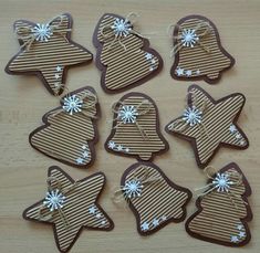 six decorated cookies are sitting on a wooden table with string and bow around the edges