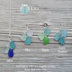 four different colored sea glass necklaces on a wooden table with the names of them