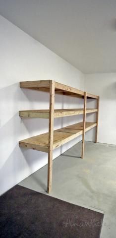 an empty room with some shelves on the wall and a blue rug in front of it