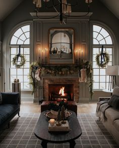 the living room is decorated for christmas with wreaths and garland on the mantel