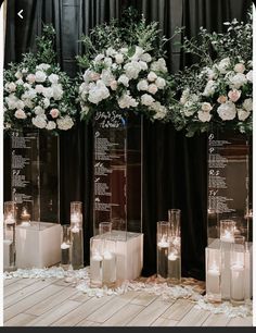 tall clear vases filled with flowers and candles