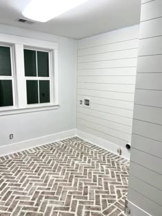 an empty room with white walls and wood flooring