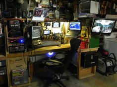 there is a desk with several computers on it and other electronic equipment in the room