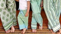 three young children standing next to each other on a rug with their feet in the air