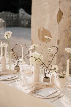 the table is set with white flowers and candles