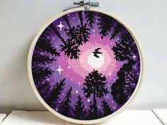 a cross stitch pattern with trees and stars in the background, on a white wall