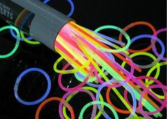 a bunch of neon colored bracelets on top of a cell phone with a black background