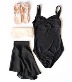 a woman's swimsuit and ballet shoes are laid out on a white surface