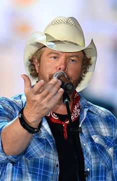 a man wearing a cowboy hat and holding a microphone