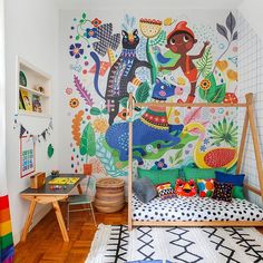 a child's room with colorful wallpaper and wooden flooring, including a bed