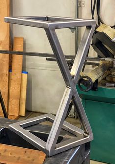 a large metal object sitting on top of a wooden table next to a green box