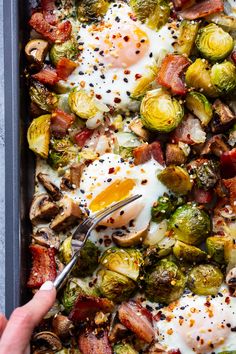 a pan filled with brussel sprouts, eggs and bacon on top