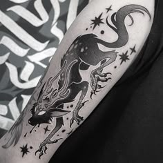 a black and white image of a dragon on the arm with stars around it's neck