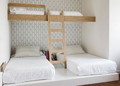 two bunk beds in a small room with white walls and patterned wallpaper on the walls