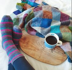 a person with their feet up on a wooden board and coffee in front of them