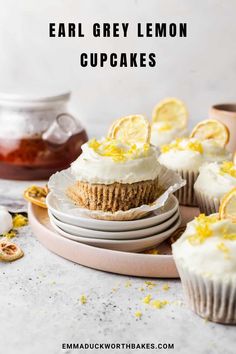 lemon cupcakes with white frosting and lemon slices on top, sitting on plates