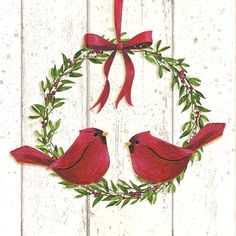 two red birds sitting on top of a wreath