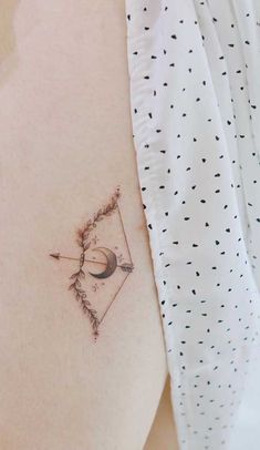 a small tattoo on the side of a woman's stomach