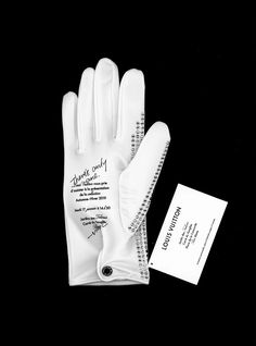 a white glove with writing on it next to a note