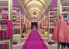 an image of a woman's clothing store with pink carpet and shelves full of clothes