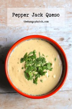 a red bowl filled with soup and garnished with cilantro