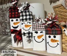 three snowman gift bags sitting on top of a shelf