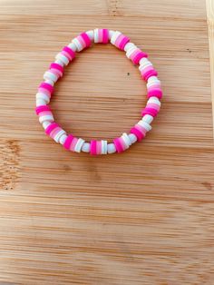 A pink and white clay bead bracelet with white seed beads Pink Beach Bracelet With Large Beads, White Heishi Beads Bracelet, White Heishi Beads Round Bracelets, Pink Large Beads Bracelet For Beach, White Heishi Beads Round Beaded Bracelets, Pink Spacer Beads, Pink Heishi Beads Bracelet, Pink Heishi Beads Jewelry With Spacer Beads, Pink Heishi Beads Bracelet With Letter Beads