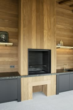 a kitchen with wood paneling and an oven in the center, built into the wall