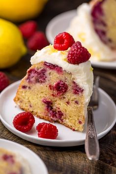 a slice of raspberry cake on a plate with a fork and lemons in the background